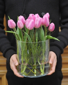 Flower arrangement with 15 pink tulips in glass vase