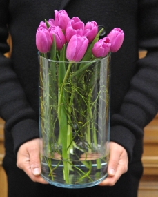 Flower arrangement with 9 purple tulips in glass vase