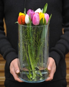  Flower arrangement with 9 various colours tulips in glass vase