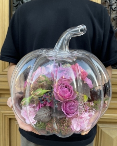 Pink floral arrangement in glass pumpkin