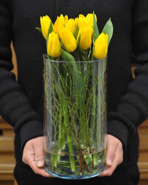 Flower arrangement with 9 yellow tulips in glass vase