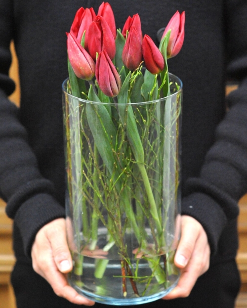 Flower arrangement with 9 red tulips in glass vase