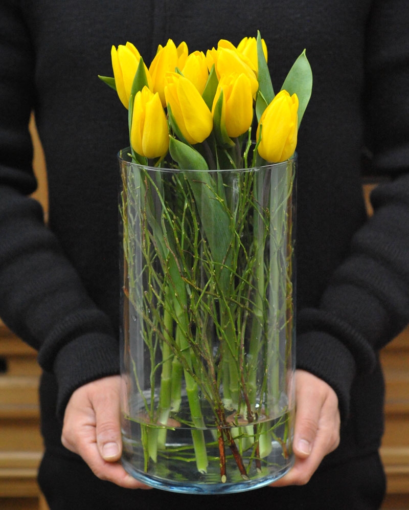 Flower arrangement with 9 yellow tulips in glass vase