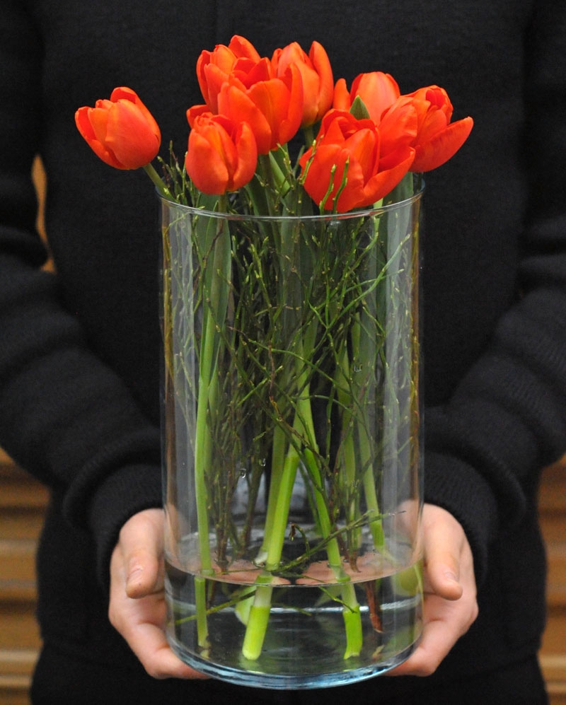  Flower arrangement with 9 orange tulips in glass vase